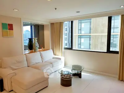 Spacious living room with modern decor and large windows offering city views.