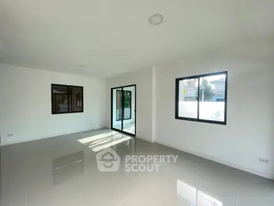 Spacious modern living room with large windows and glossy tiled floor