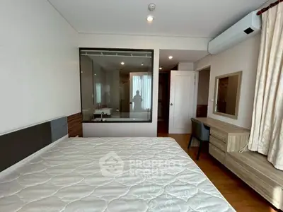 Modern bedroom with large window and stylish furniture in a contemporary apartment.