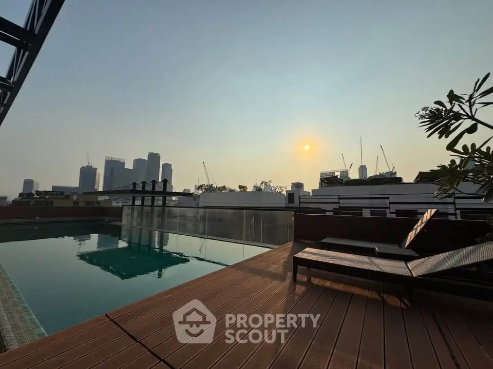 Luxurious rooftop pool with stunning city skyline view at sunset, perfect for relaxation and leisure.