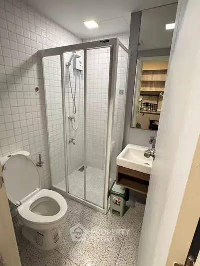 Compact modern bathroom with shower enclosure and white tiles