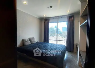 Spacious bedroom with city view and modern decor in a high-rise apartment.