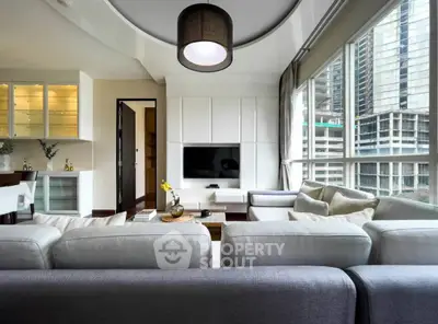 Modern living room with large windows and city view, featuring stylish furniture and contemporary lighting.