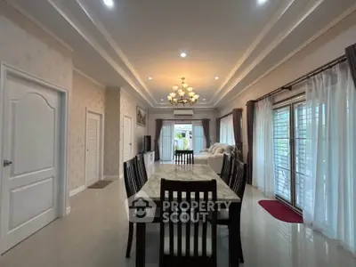 Spacious dining and living area with elegant lighting and large windows for natural light.