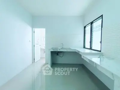Spacious modern kitchen with sleek countertops and large windows for natural light.