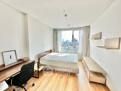 Modern bedroom with city view, featuring sleek furniture and natural light.