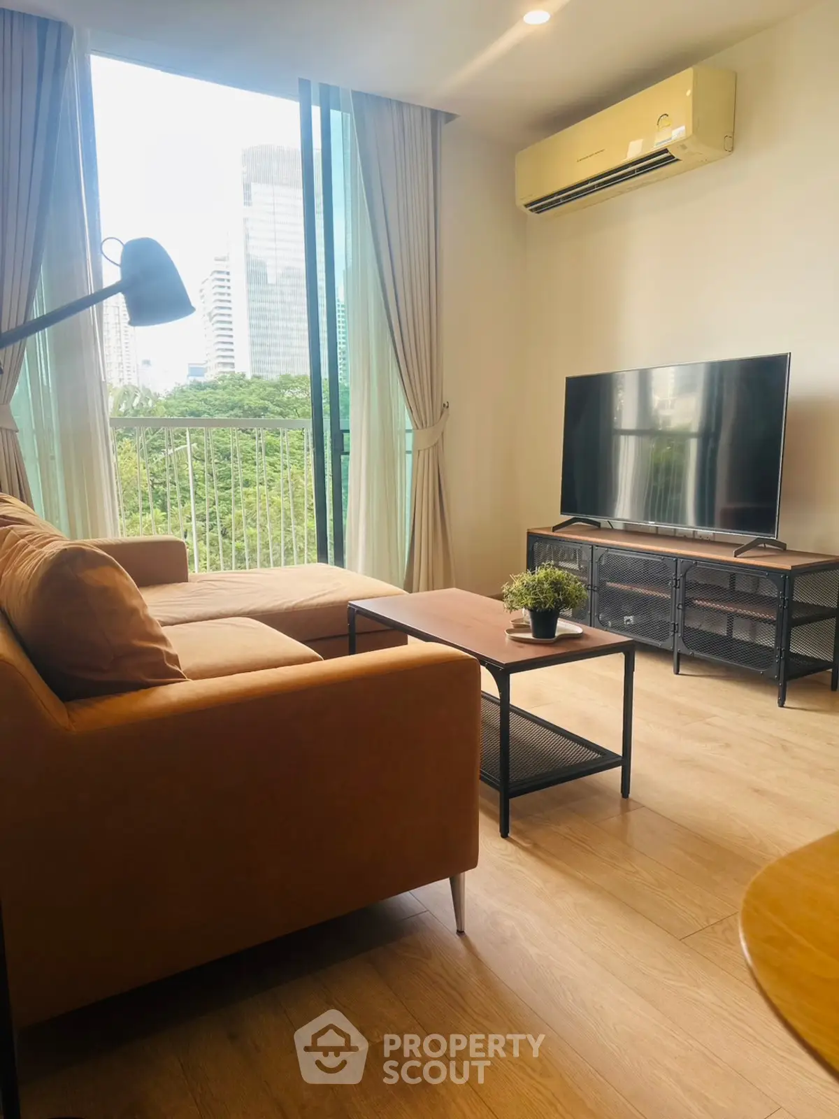 Modern living room with balcony view, stylish furniture, and natural light.