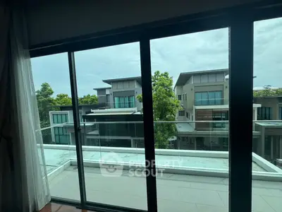 Modern balcony view overlooking contemporary residential buildings and lush greenery.