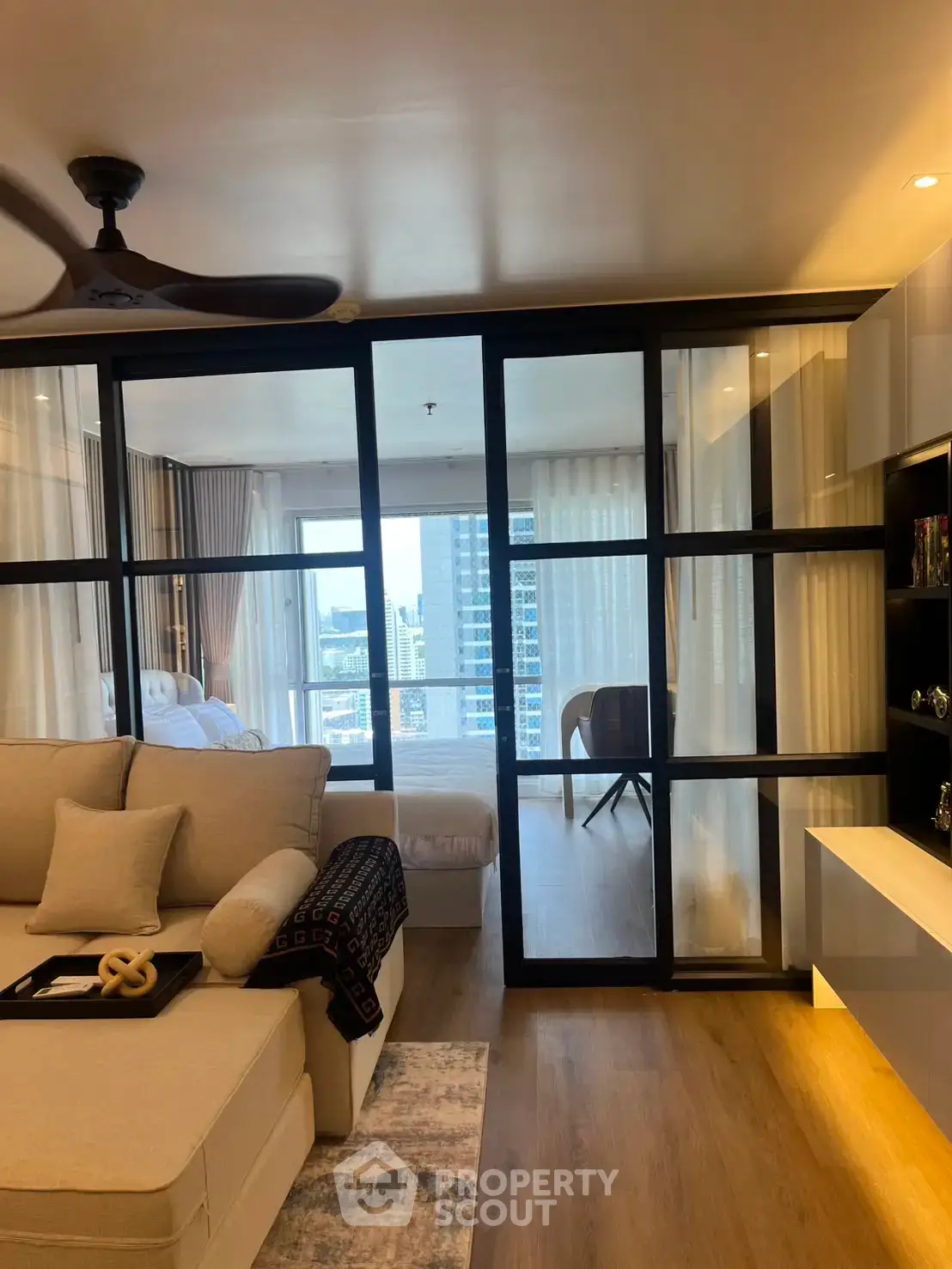 Modern living room with glass partition and city view balcony