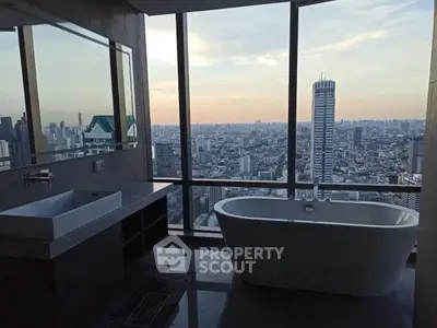 Luxurious bathroom with stunning city skyline view and modern freestanding bathtub.