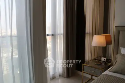 Luxurious bedroom with elegant curtains and stylish bedside lamp