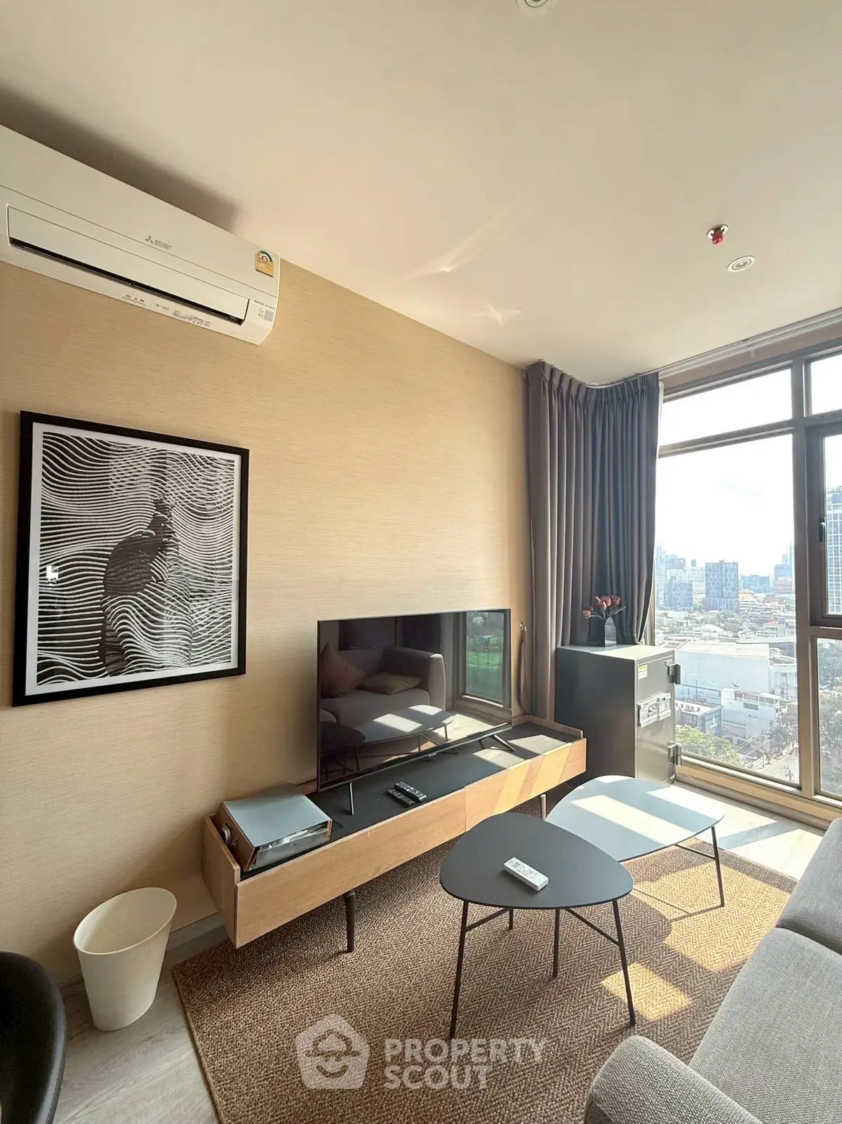 Modern living room with city view, stylish furniture, and natural light.