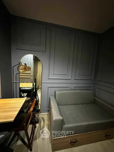 Modern living room with stylish gray sofa and elegant wooden dining table in cozy apartment.