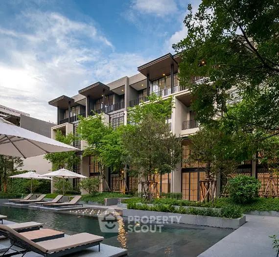 Luxurious modern apartment building with pool and lush greenery