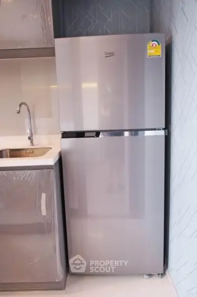 Modern kitchen with sleek stainless steel refrigerator and stylish cabinetry.