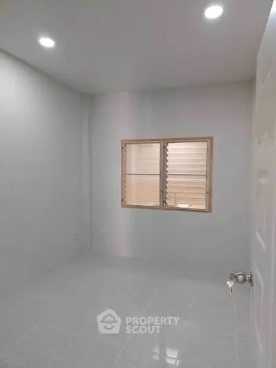 Minimalist empty room with tiled floor and window, perfect for customization.