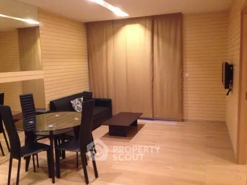 Modern living room with sleek black furniture and wooden panel walls, perfect for stylish urban living.