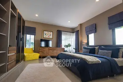 Spacious modern bedroom with stylish decor and ample natural light.