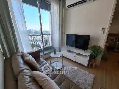 Modern living room with city view, featuring cozy sofa and sleek TV setup.