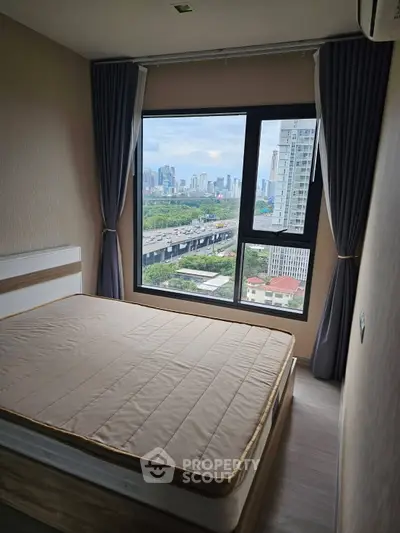 Modern bedroom with city view, featuring large window and stylish decor, perfect for urban living.