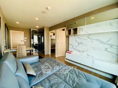 Modern living room with sleek design and marble accent wall in luxury apartment.