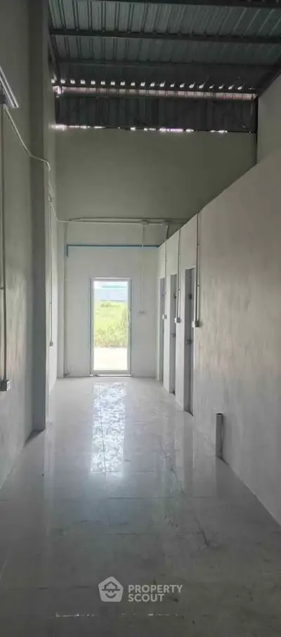 Spacious industrial-style corridor with high ceiling and natural light