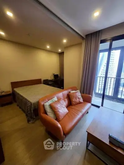 Modern studio apartment with cozy living area and balcony view
