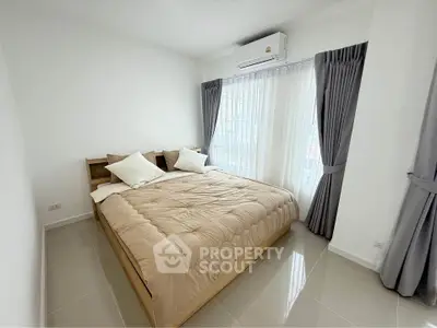 Modern bedroom with large windows and air conditioning in a bright apartment.