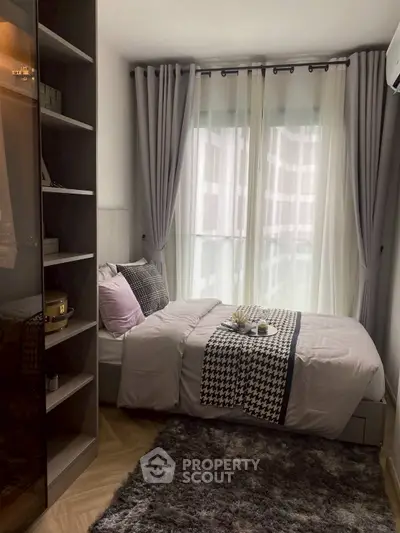 Cozy modern bedroom with stylish decor and large window for natural light.