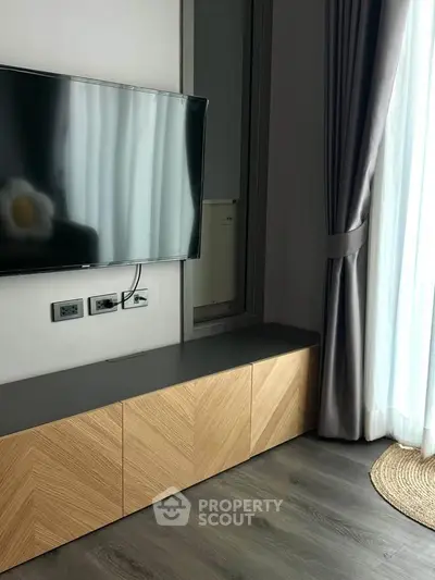 Modern living room with wall-mounted TV and stylish wooden cabinet