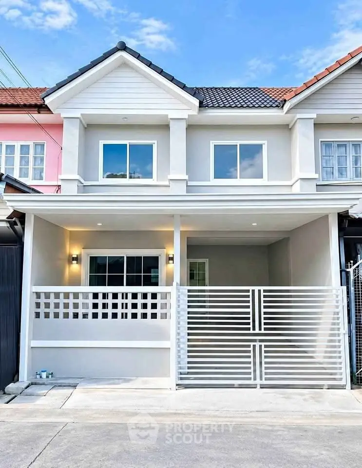 Charming townhouse with modern facade and gated entrance in a vibrant neighborhood.
