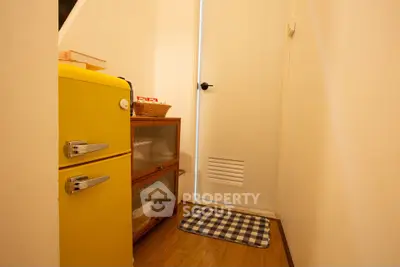 Charming storage nook with retro yellow fridge and cozy decor