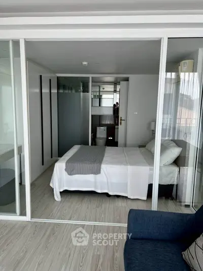 Modern bedroom with glass walls and minimalist decor in a stylish apartment.