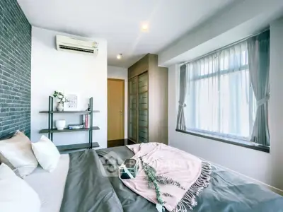 Modern bedroom with stylish decor and large window for natural light.