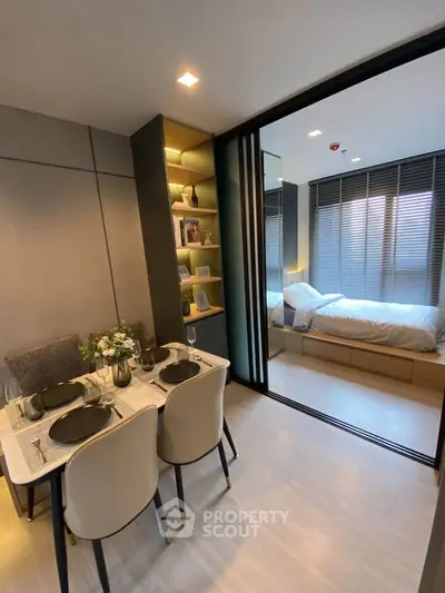 Modern open-plan living and dining area with sliding doors to a cozy bedroom, perfect for urban living.