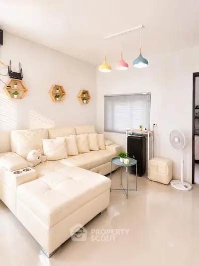 Modern living room with stylish lighting and cozy white sectional sofa.