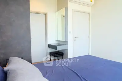 Modern bedroom with sleek design and air conditioning, featuring a stylish vanity area.