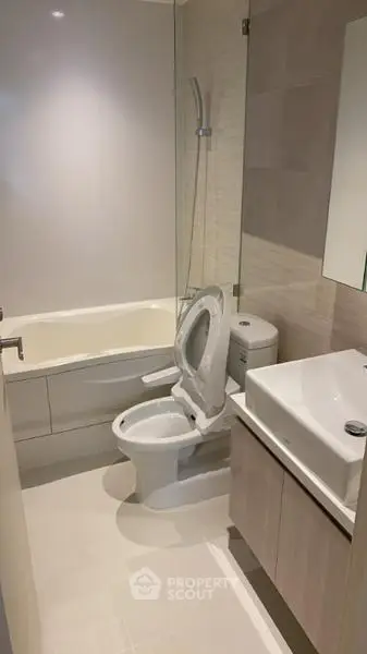 Modern bathroom with sleek fixtures and bathtub in contemporary apartment.