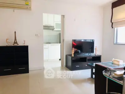 Modern living room with sleek furniture and open kitchen view, perfect for urban living.