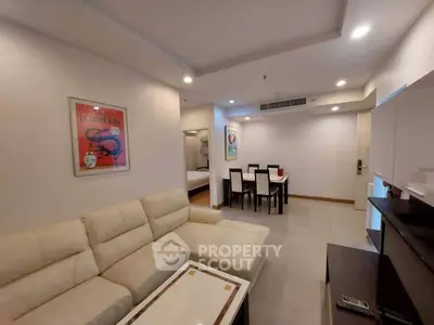 Spacious living room with modern decor and dining area in open layout apartment.