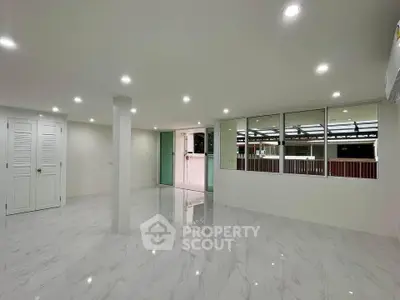 Spacious modern living room with glossy marble floors and ample lighting
