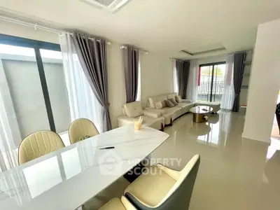 Spacious modern living room with elegant furniture and large windows.