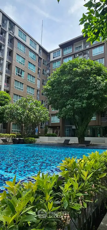 Luxurious residential building with a stunning pool and lush greenery, perfect for modern living.