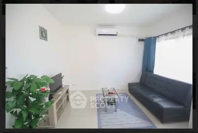 Modern living room with sleek black sofa and air conditioning