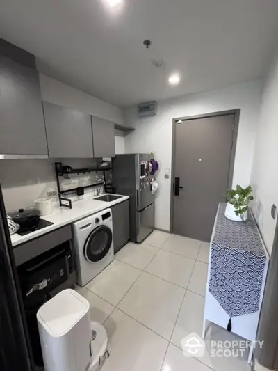 Modern kitchen with washing machine and fridge in compact layout