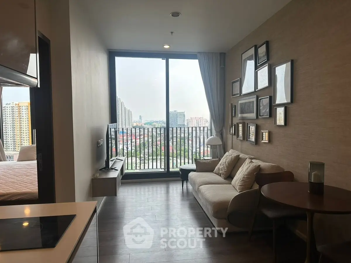 Modern living room with balcony view in a high-rise apartment, featuring stylish decor and ample natural light.