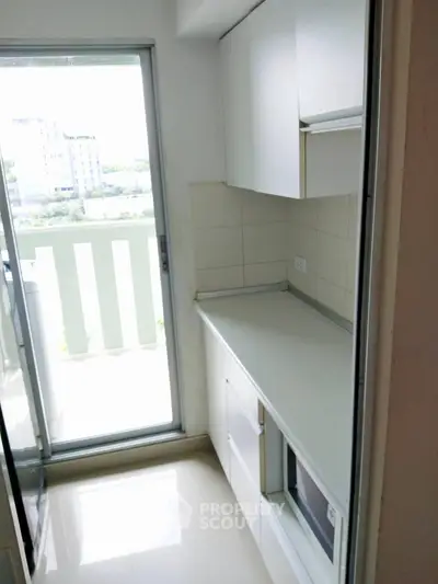 Compact kitchen with balcony access and modern cabinetry