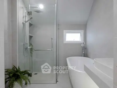 Modern bathroom with glass shower and freestanding bathtub in elegant design.
