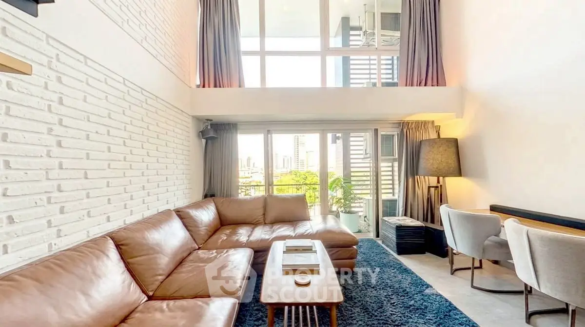 Spacious modern living room with high ceilings and large windows offering city views.