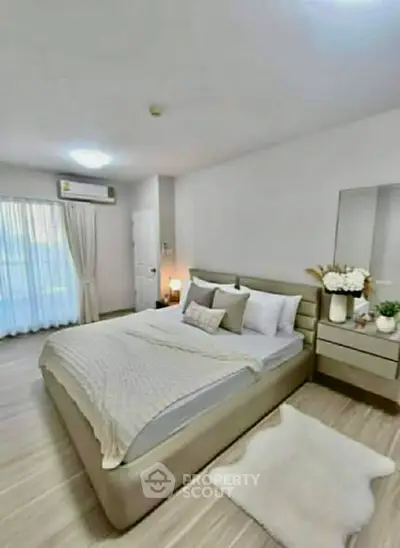 Modern bedroom with elegant decor and natural light, featuring a cozy bed and stylish furnishings.
